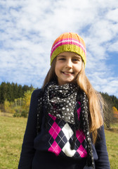 happy little girl in autumn clothes walking outdoor