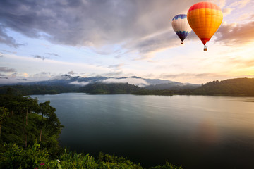 Hot air balloons floating over lake