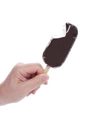 Hand holds bitten chocolate vanilla ice cream
