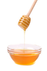 Honey dripping from a wooden dipper.