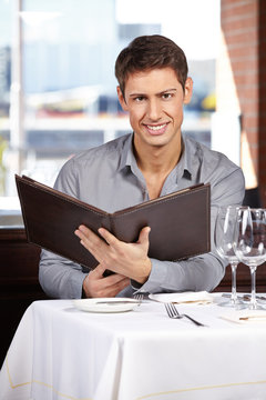 Man reading menu at restaurant