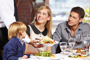 Serveur servant la famille au restaurant