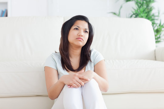 Woman is sitting in front of a couch