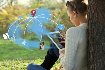 young woman using her tablet pc during rest in the park