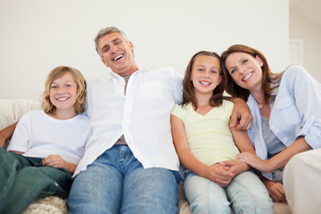 Obraz premium Laughing family sitting on the couch