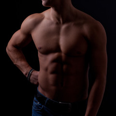 Fototapeta na wymiar Perfect male body on black background.