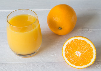 Orangensaft im Glas und Orange