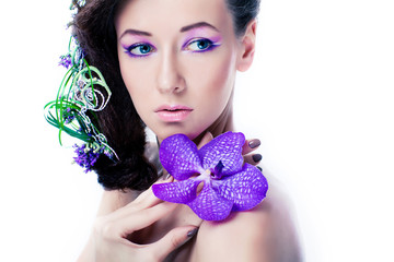 Beauty girl with orchid flowers and professional makeup