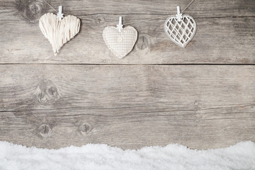 white hearts on wooden background with snowflake
