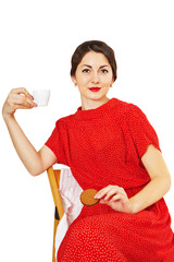 Woman holding a cup of coffee and cookies