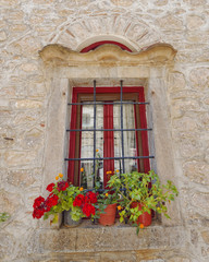Fototapeta na wymiar picturesque window and flowerpots, Greece