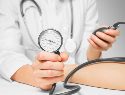 Doctor measures blood pressure by sphygmomanometer