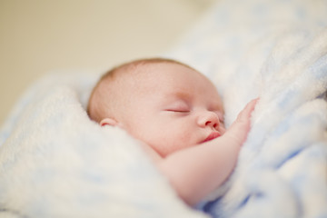 Niemowlę śpi zawinięte w kocyk