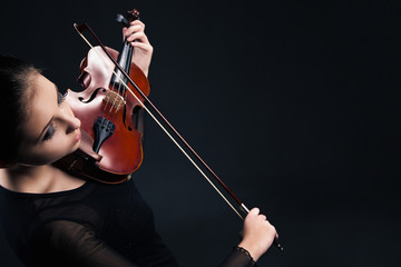 Beautiful young woman playing violin over black © julenochek