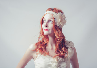 Portrait of a beautiful red haired woman with flower in her hair