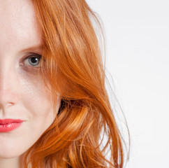 Half face portrait of a beautiful 20 year old redhead woman.