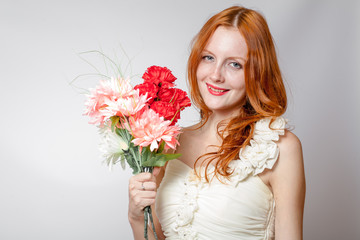 Beautiful redheaded girl with flowers studio shot