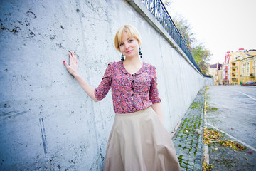 Pretty girl stay near the wall