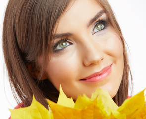 Fototapeta premium Yellow autumn leaves, close up woman face