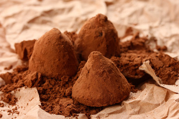 Chocolate truffles and cocoa, on brown background