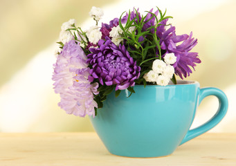 Beautiful bouquet of bright flowers in color mug,
