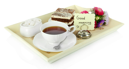 Cup of tea with cakes on wooden tray isolated on white
