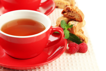 Cup of tea with cookies and raspberries close-up