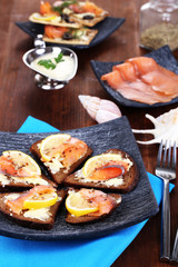 Salmon sandwiches on plate  on wooden table close-up