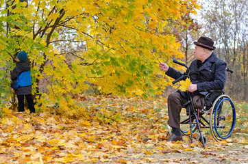 Obraz premium Disabled grandfather and grandchild outdoors playing