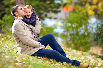 happy father and son having fun in autumn park