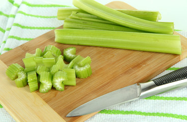 Fresh green celery on cutting board close-up