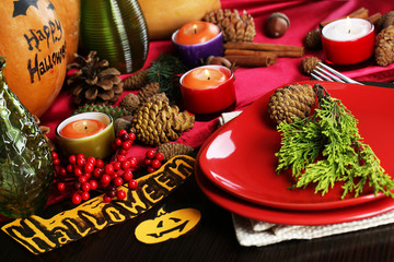 Table setting for Halloween with pumpkin and candles close-up