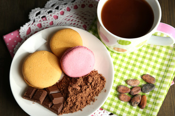 Cocoa in cup with sweets and cocoa powder