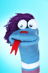Cute sock puppet on blue background
