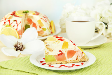 Delicious jelly cake on table on light background