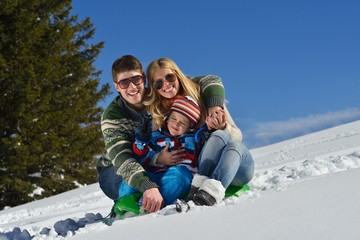 family having fun on fresh snow at winter