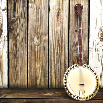 Banjo leaning on a wooden fence. Room for advertisment