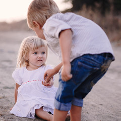 Fototapeta premium Preteen girl and boy holding their hands