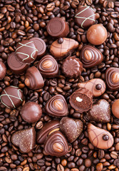 Assorted chocolate pralines on coffee beans background