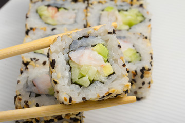 California sushi roll with sesame on white dish
