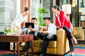 Asian Chinese business people meeting in hotel lobby