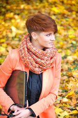 Cute woman with laptop in the autumn park