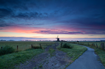 Dutch windmill on meadow at sunrise