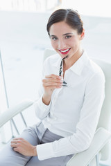 Smiling young business woman sitting on sofa