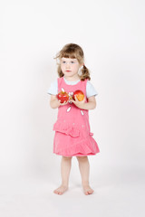 Little happy barefoot girl holds two red apples in hands on whit
