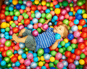 Fototapeta na wymiar Happy child playing with colorful plastic balls