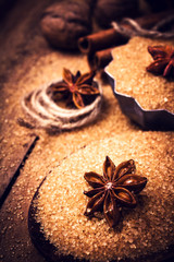 Cinnamon sticks and star anise on brown cane sugar on wooden bac
