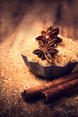 Cinnamon sticks and star anise on brown  sugar on wooden backgro