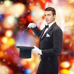 magician in top hat with magic wand showing trick