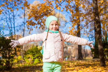 Little happy girl in autumn park